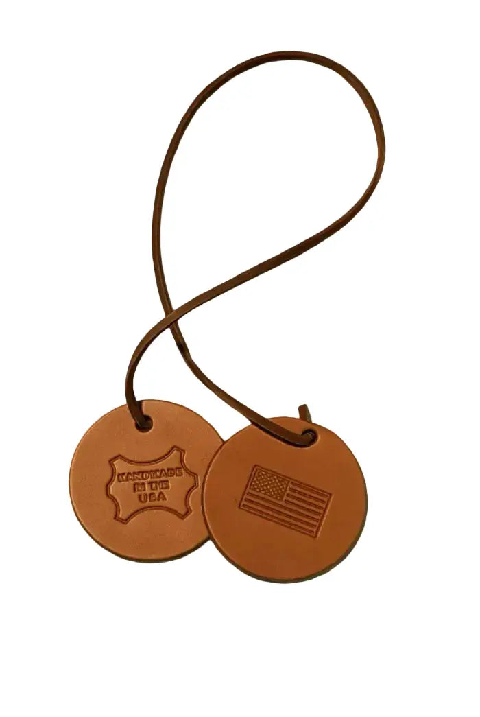 Two brown leather tags with embossed designs on a white background